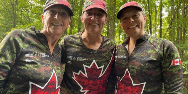 Three women wearing Canada Army Run gear smile for the camera. | Trois femmes vêtues de tenues de la Course de l'Armée du Canada sourient à la caméra.