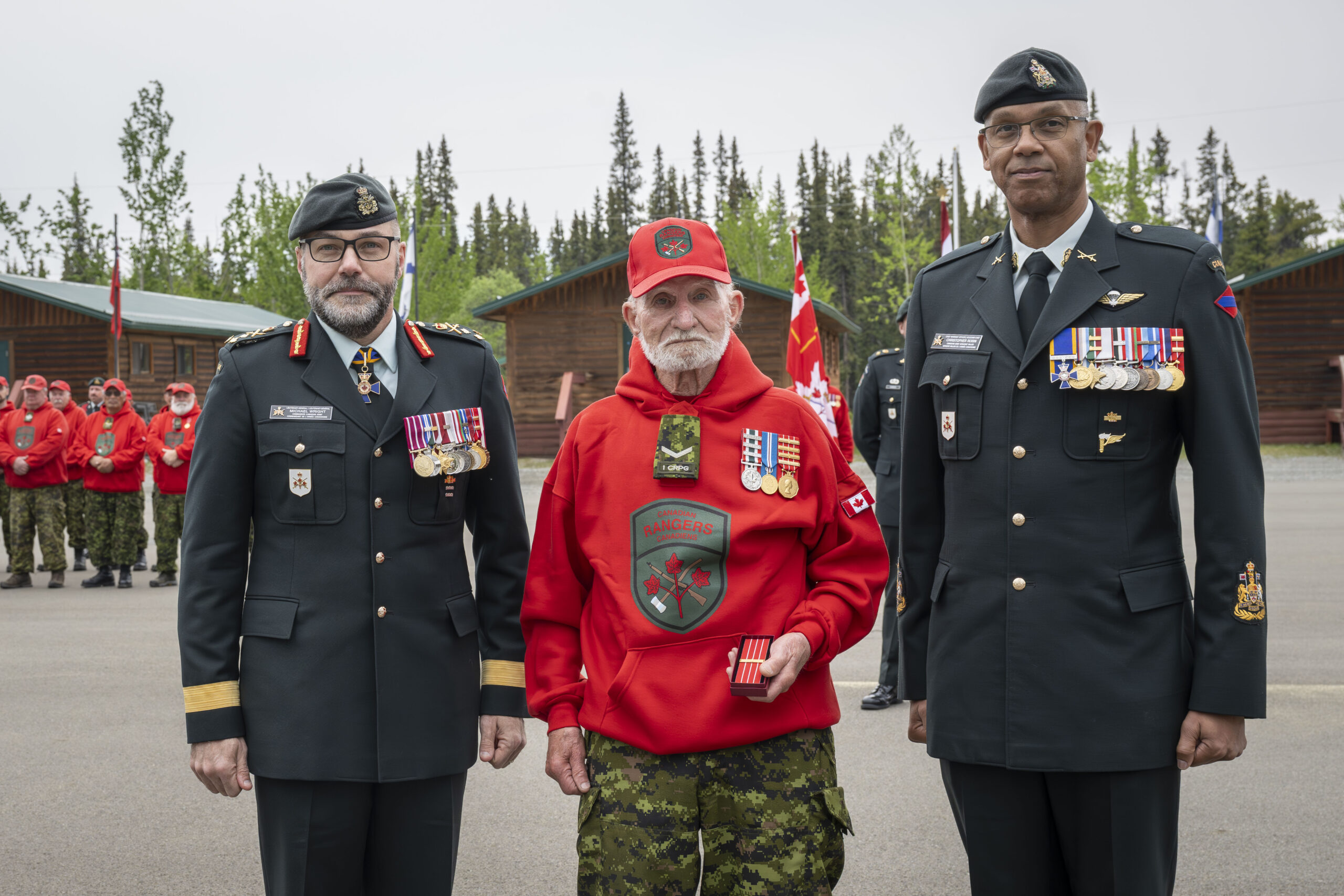 Canadian Ranger Richard Newell (center) is presented with the Canadian Forces Decoration fifth clasp by Lieutenant-General Micheal Wright, Commander Canadian Army (left), and Chief Warrant Officer Christopher Robin, the Army Sergeant Major (right), during a ceremony in Whitehorse, Yukon, on 13 June 2025.