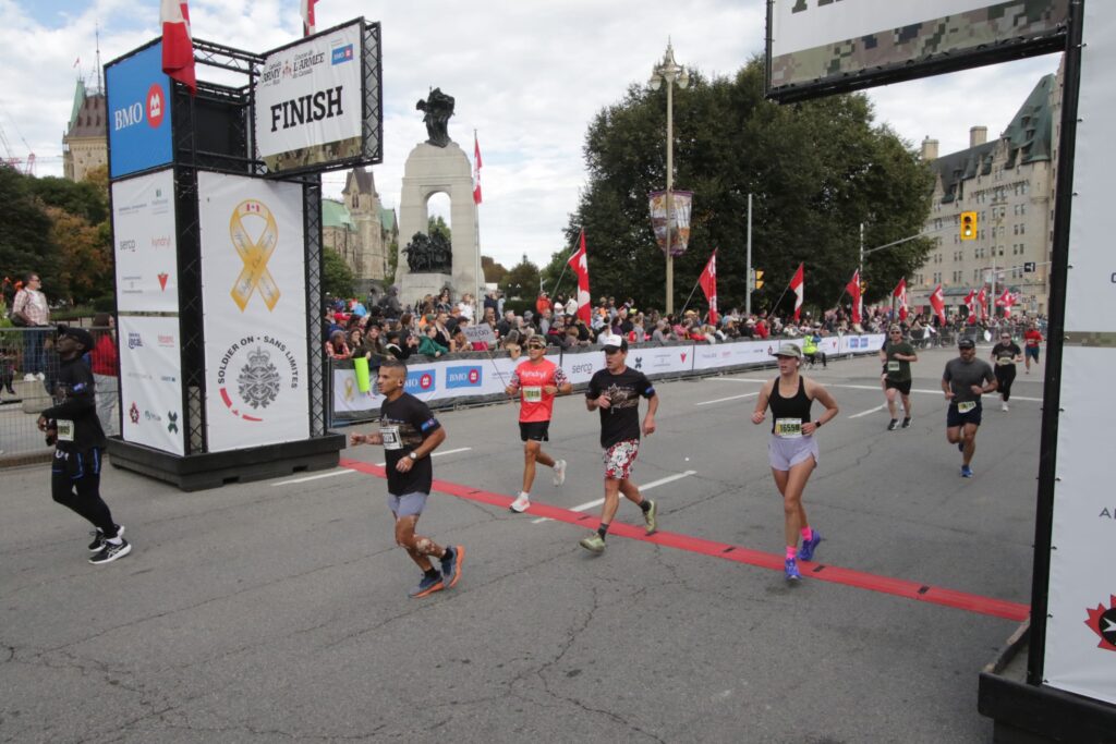 Runners cross teh Canada Army Run finish line. | Les coureurs franchissent la ligne d’arrivée de la Course de l’Armée du Canada.
