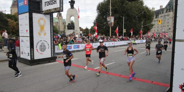 Runners cross teh Canada Army Run finish line. | Les coureurs franchissent la ligne d’arrivée de la Course de l’Armée du Canada.