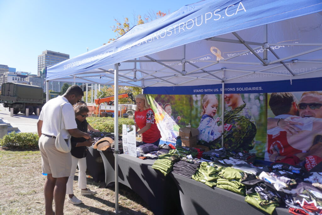 Shirts are sold under a large tent. | Les chandails sont vendues sous une grande tente.